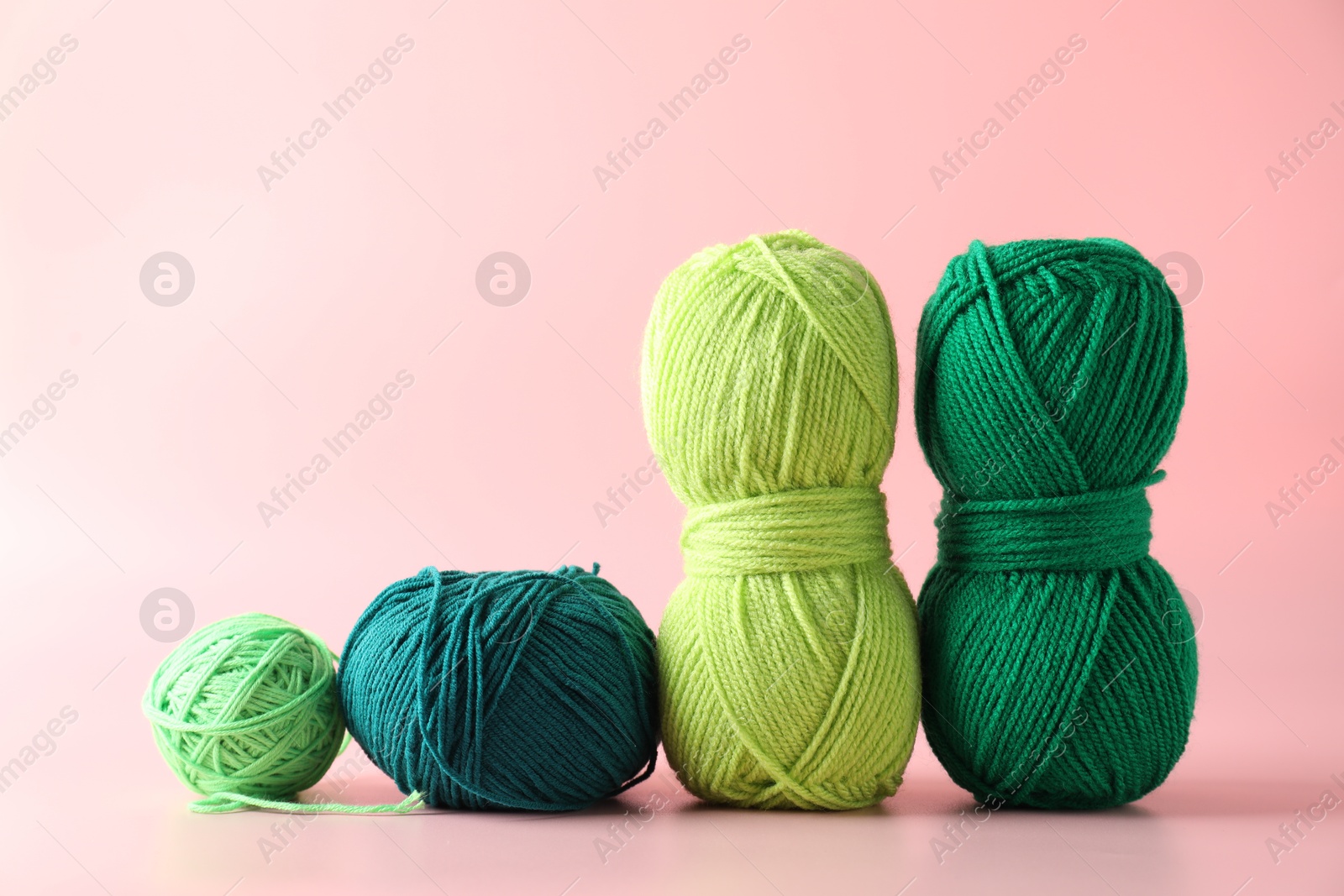 Photo of Different colorful yarns on pink background. Knitting material