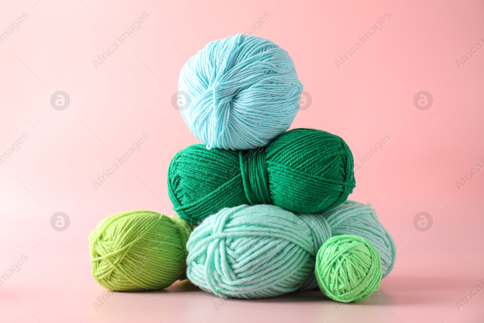 Photo of Pile of different colorful yarns on pink background