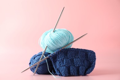 Photo of Different yarns, knitting needles and pattern sample on pink background