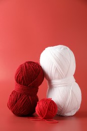 Different colorful yarns on red background. Knitting material