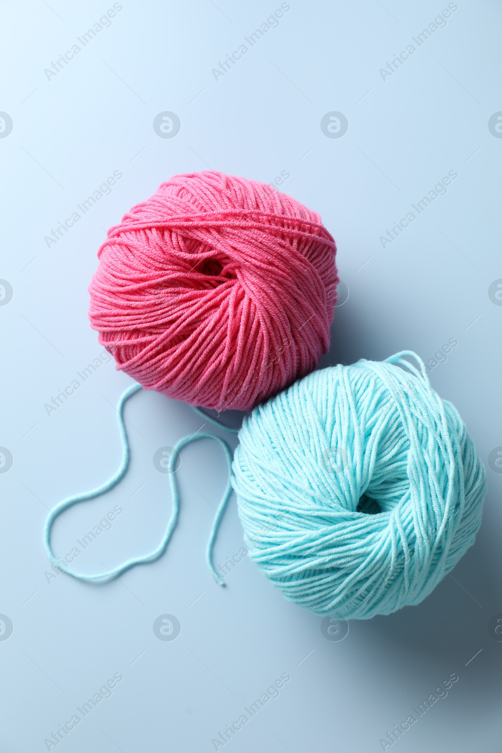 Photo of Colorful yarns on light blue background, flat lay