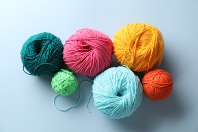 Different colorful yarns on light blue background, flat lay