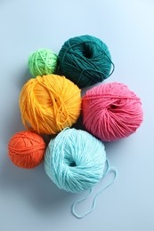 Photo of Different colorful yarns on light blue background, flat lay