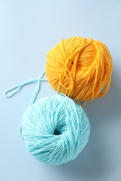 Colorful yarns on light blue background, flat lay