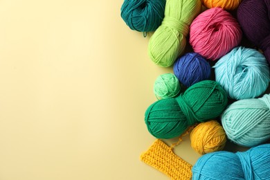 Photo of Different yarns and pattern sample on yellow background, flat lay. Space for text