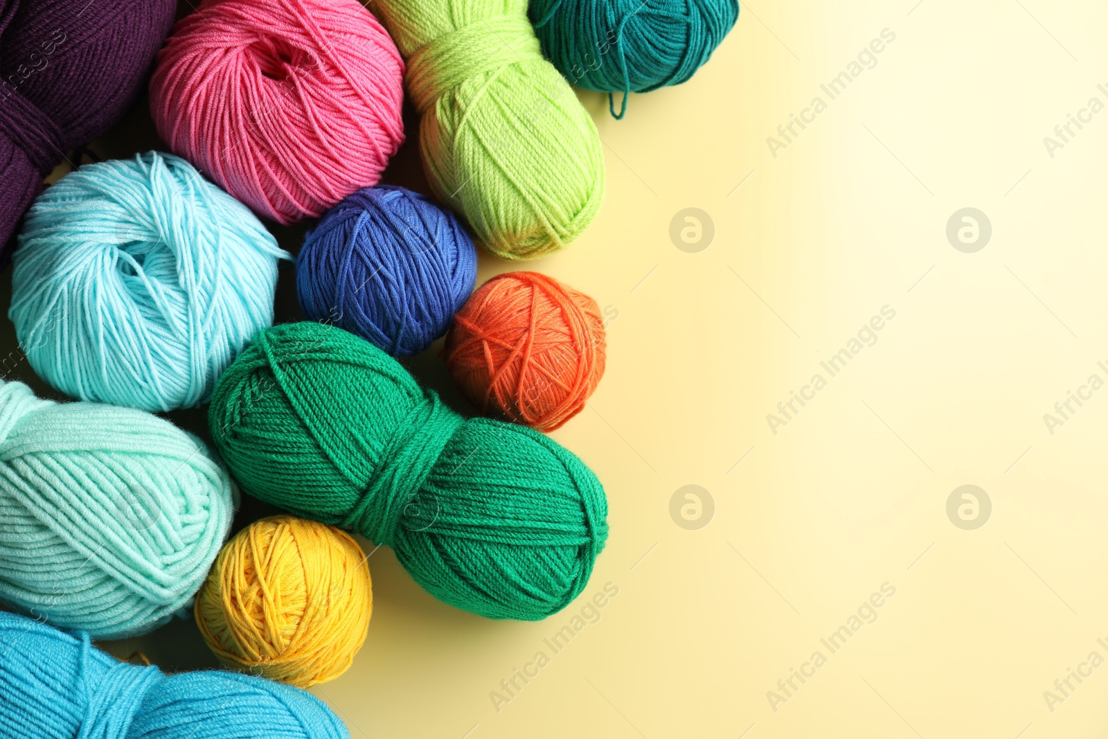 Photo of Different yarns on yellow background, flat lay. Space for text