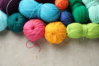 Photo of Different yarns on grey textured table, flat lay. Space for text