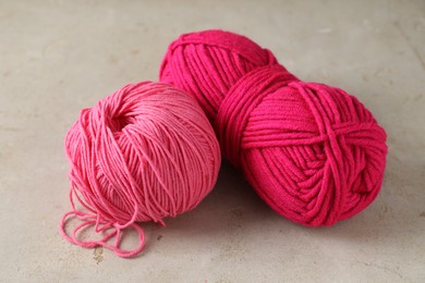 Two colorful yarns on light textured table, closeup