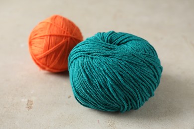 Two colorful yarns on light textured table, closeup