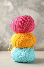 Photo of Stack of different colorful yarns on light table, closeup