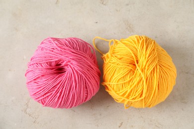 Photo of Two colorful yarns on light textured table, flat lay