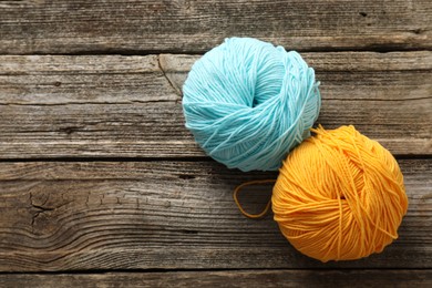 Photo of Two colorful yarns on wooden table, flat lay. Space for text