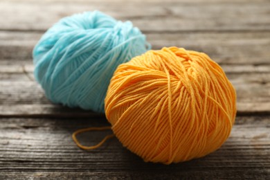 Two colorful yarns on wooden table, closeup