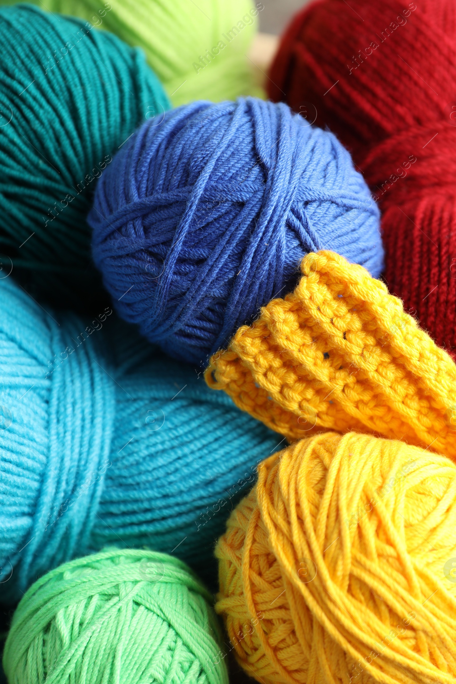 Photo of Many different yarns and knitting sample as background, above view