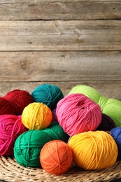 Photo of Pile of different yarns on wicker mat, closeup. Space for text