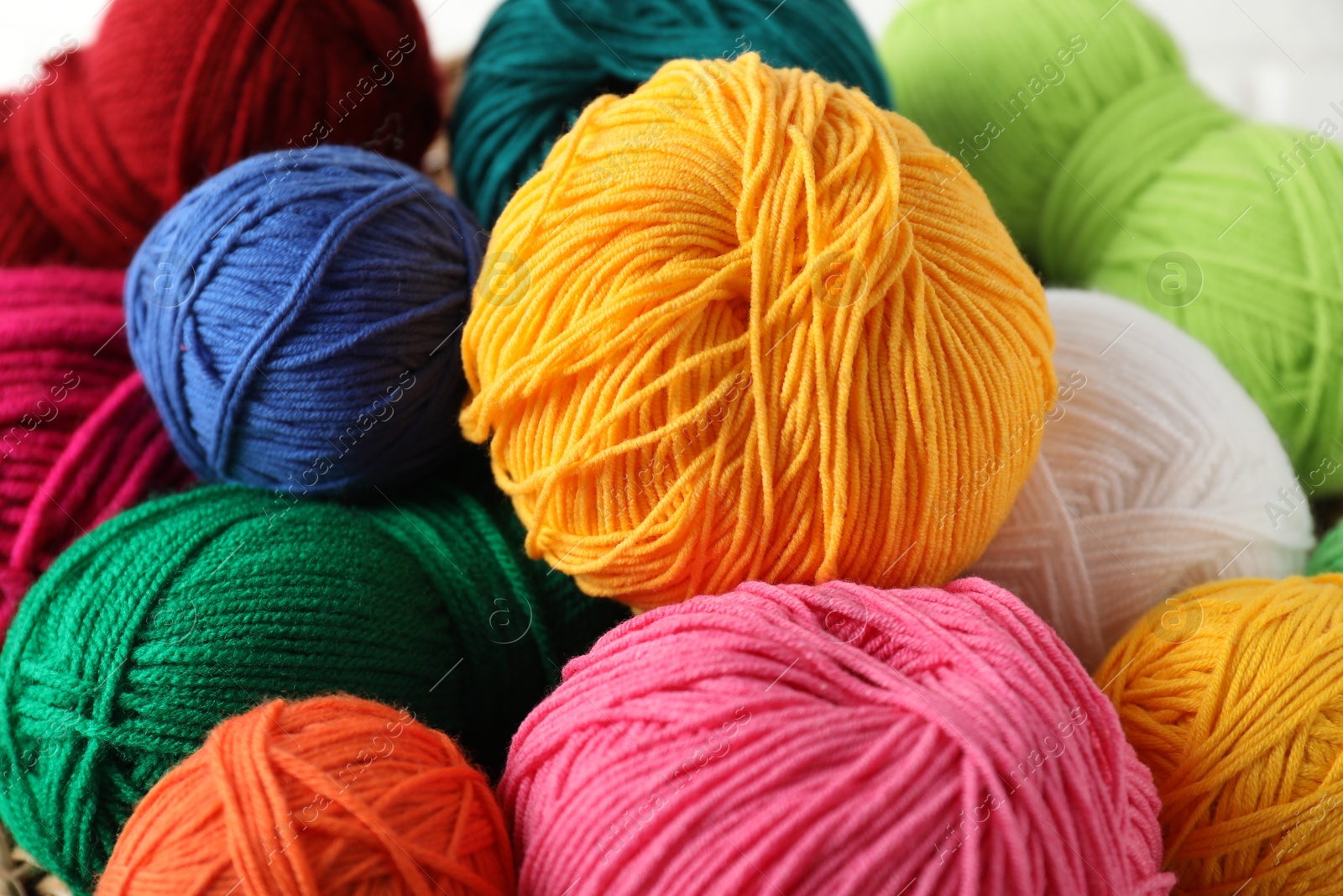 Photo of Many different yarns on blurred background, closeup