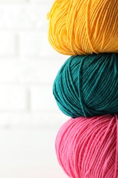 Photo of Different colorful yarns on blurred white background, closeup. Space for text