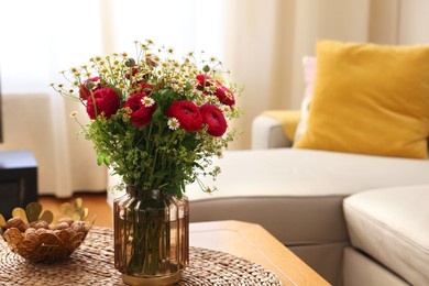 Photo of Beautiful ranunculus flowers and chamomiles in vase on table indoors