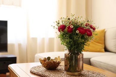 Photo of Beautiful ranunculus flowers and chamomiles in vase on table indoors. Space for text