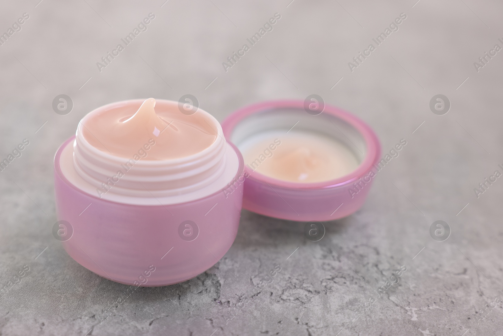 Photo of Jar of cream on gray table, closeup