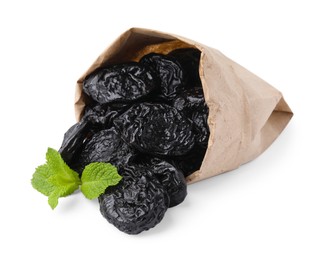 Photo of Paper bag with tasty dried plums (prunes) and mint isolated on white