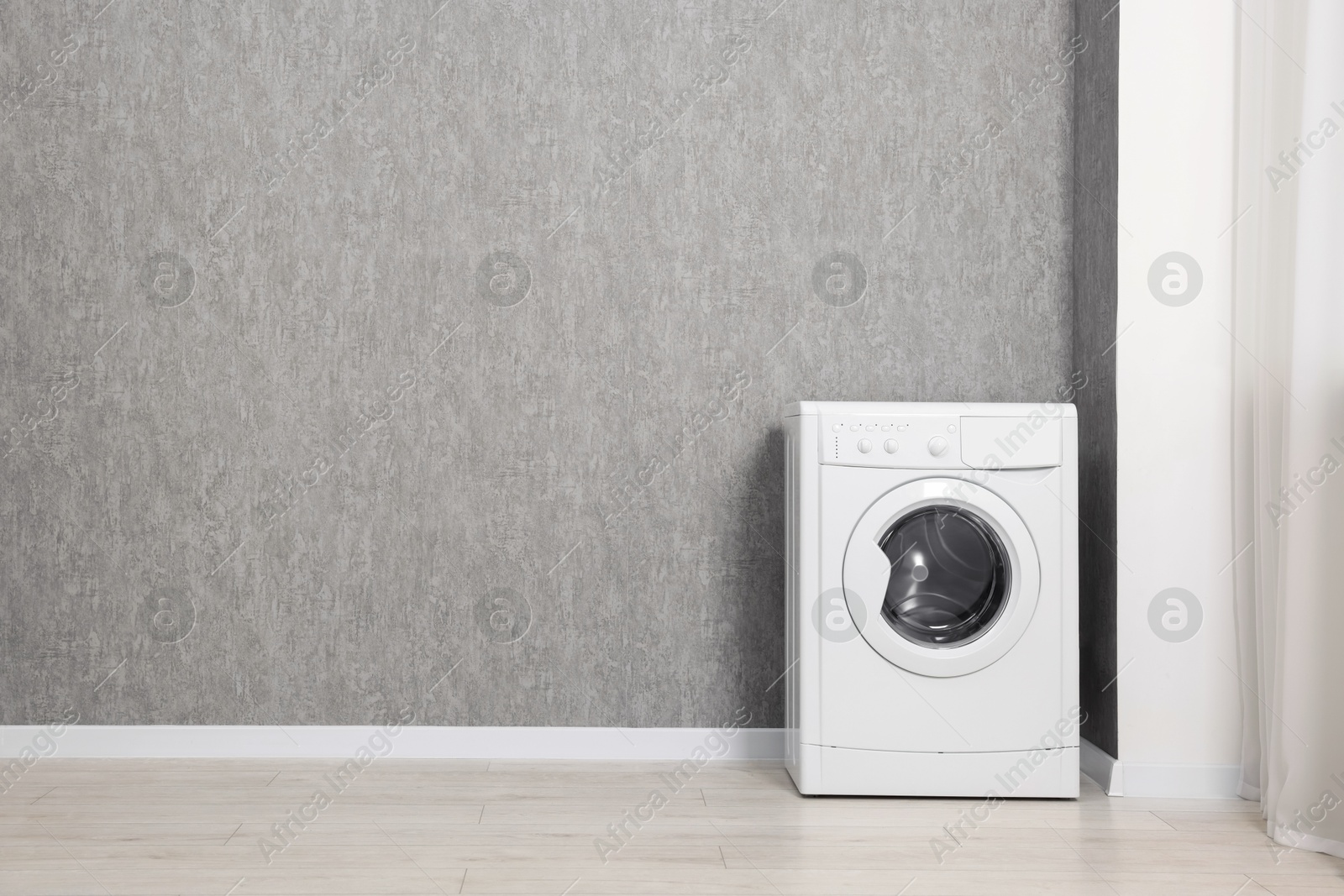 Photo of Washing machine near grey wall indoors, space for text