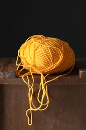 Photo of Skein of orange yarn on wooden stand