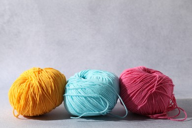 Soft skeins of yarn on light grey background, space for text