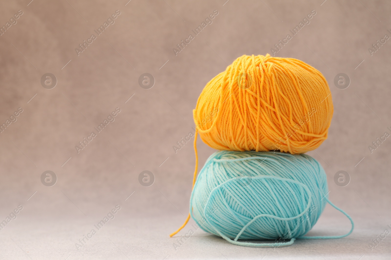 Photo of Two soft skeins of yarn on beige background, space for text