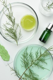 Photo of Petri dishes with green twigs and cosmetic products on white background, flat lay