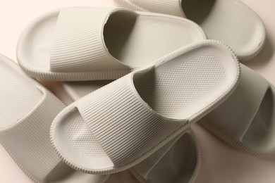 Photo of Pairs of rubber slippers on beige background, top view