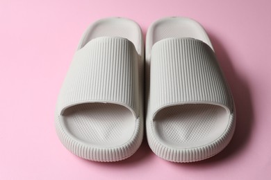 Pair of rubber slippers on pink background, closeup