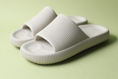 Pair of rubber slippers on green background