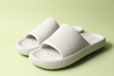 Photo of Pair of rubber slippers on green background