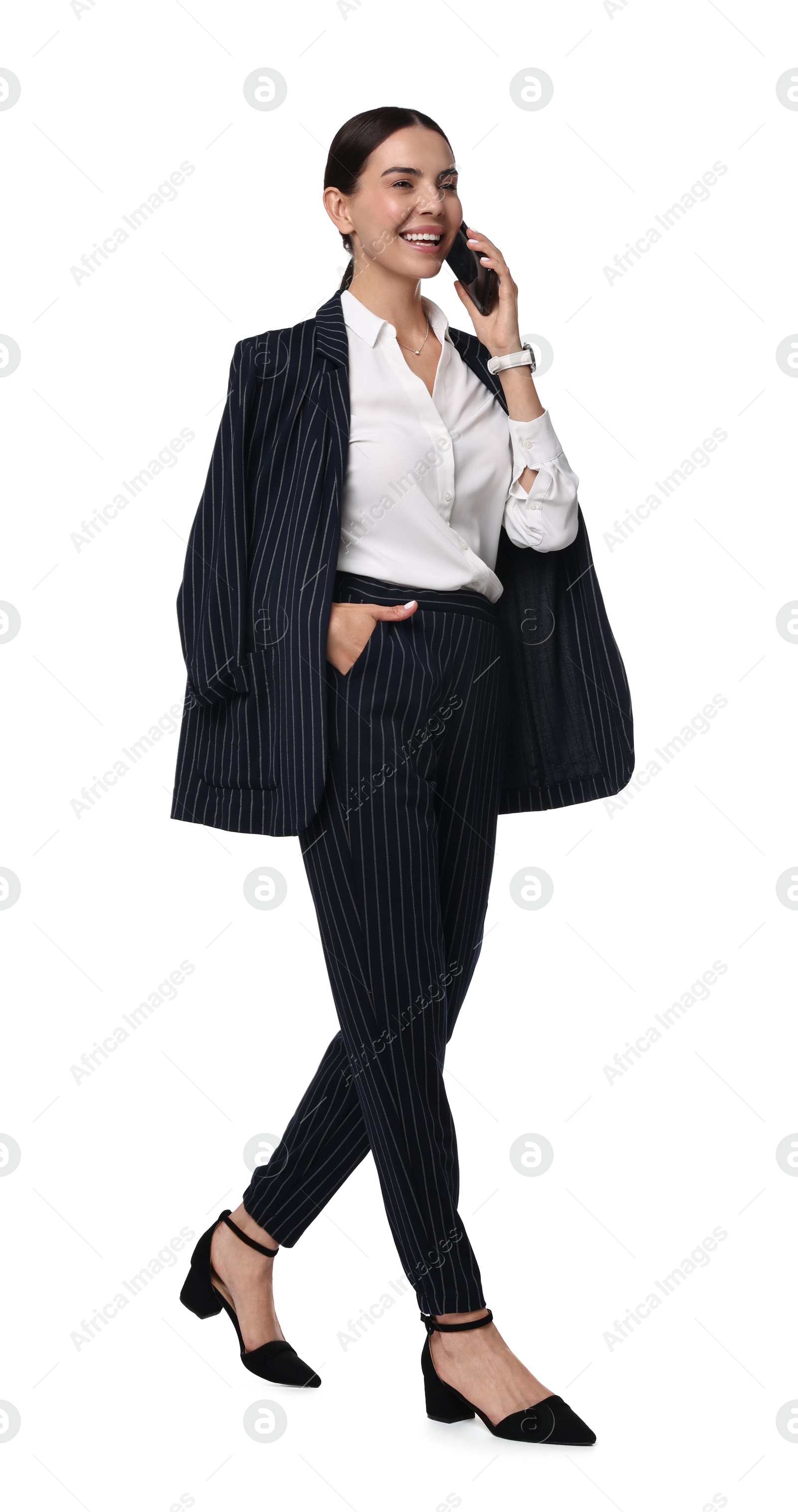 Photo of Beautiful woman in black striped suit talking on phone while walking against white background