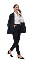 Beautiful woman in black striped suit talking on phone while walking against white background