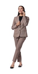 Beautiful woman in beige suit talking on phone against white background