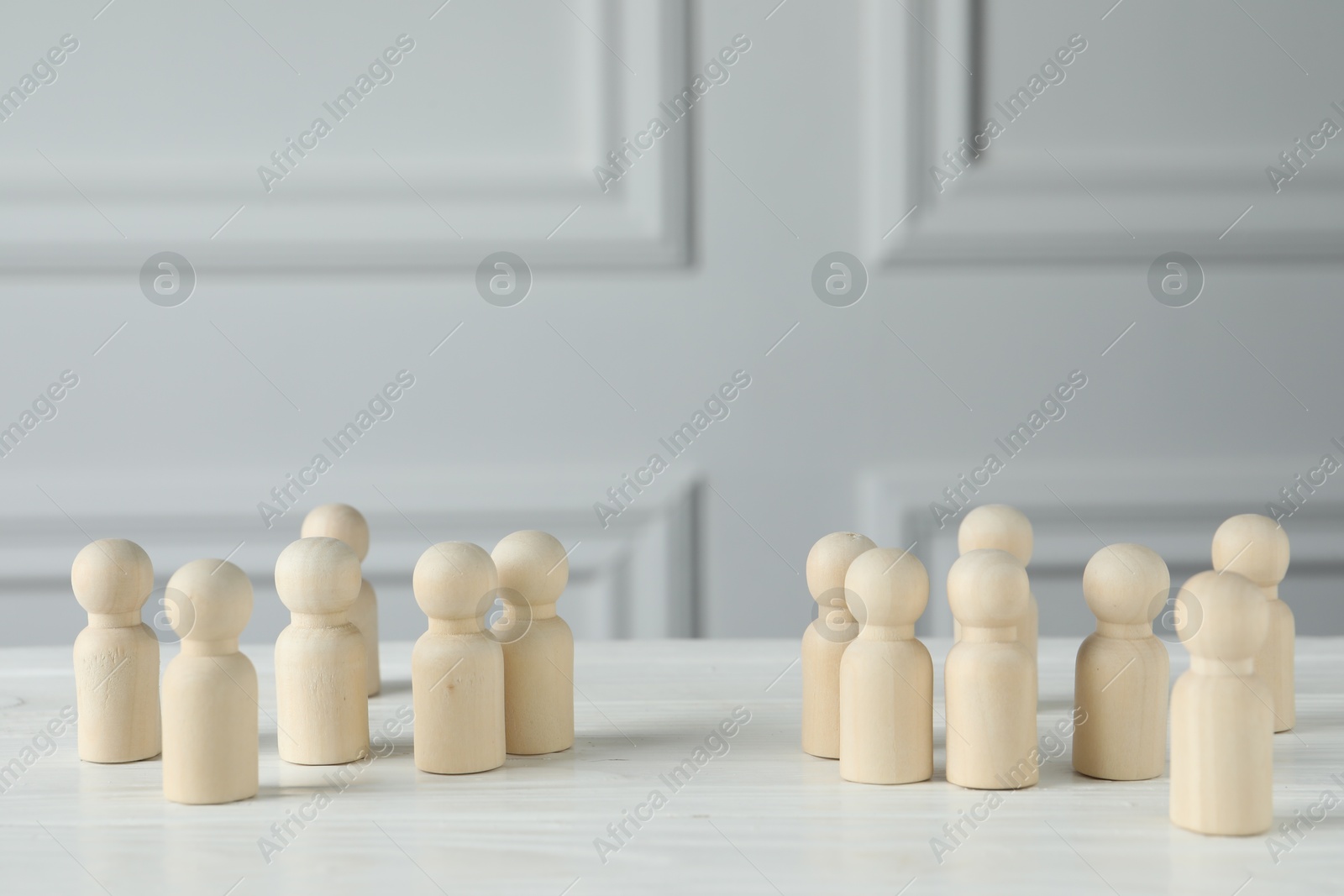 Photo of Group of wooden human figures on white table