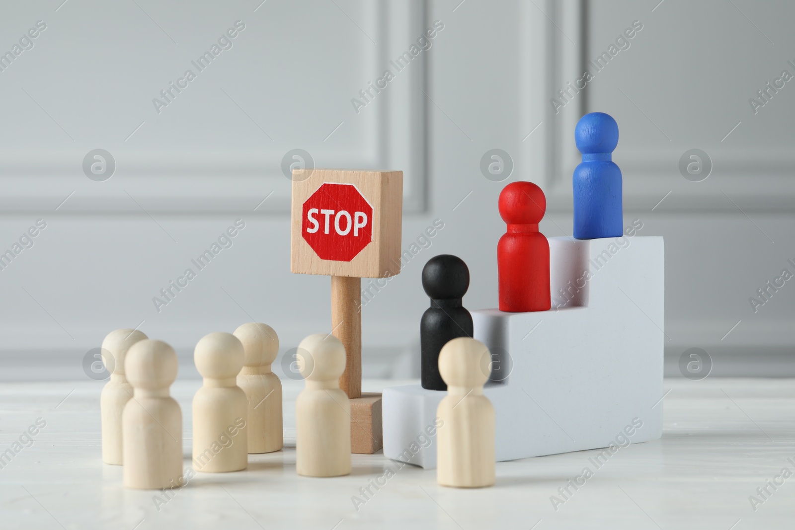 Photo of Road Stop sign blocking way for wooden human figures on white table