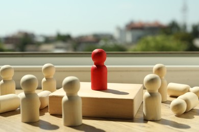 Photo of Red piece among wooden ones on windowsill