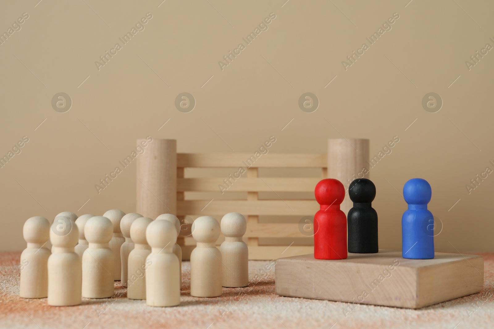 Photo of Different human figures on table against beige background