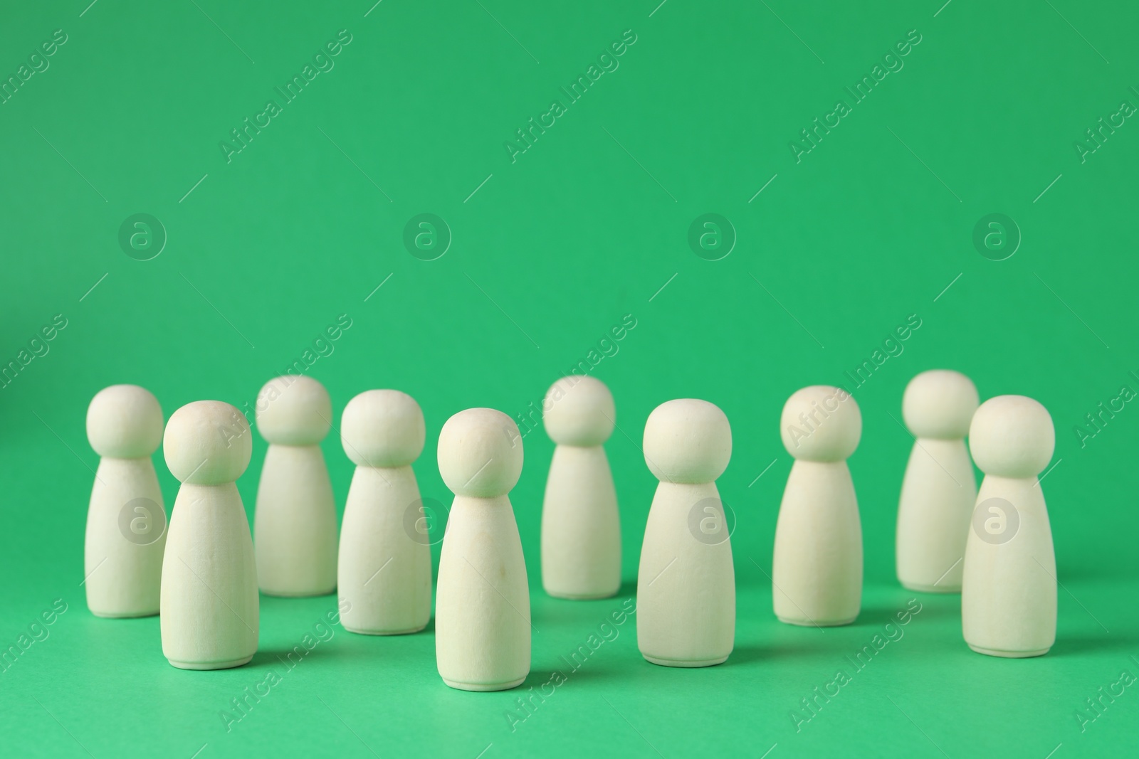 Photo of Group of wooden human figures on green background