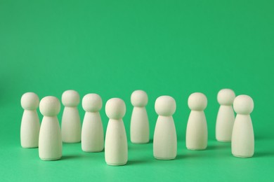 Photo of Group of wooden human figures on green background