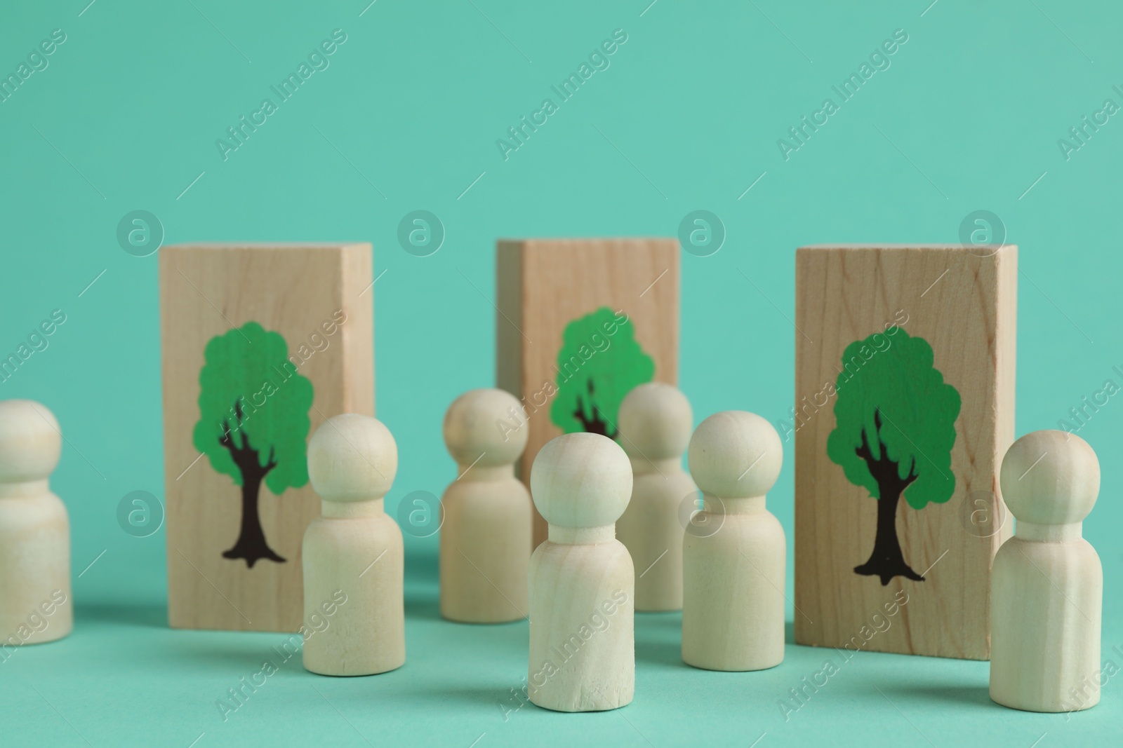 Photo of Human figures and drawn trees on wooden planks against turquoise background