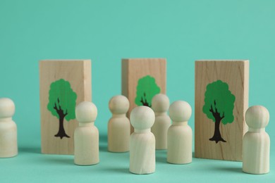 Human figures and drawn trees on wooden planks against turquoise background