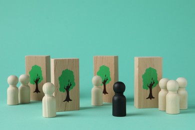 Black piece among wooden ones and drawn trees on planks against turquoise background