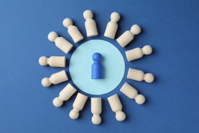 Photo of Bright piece among wooden ones on blue background, top view