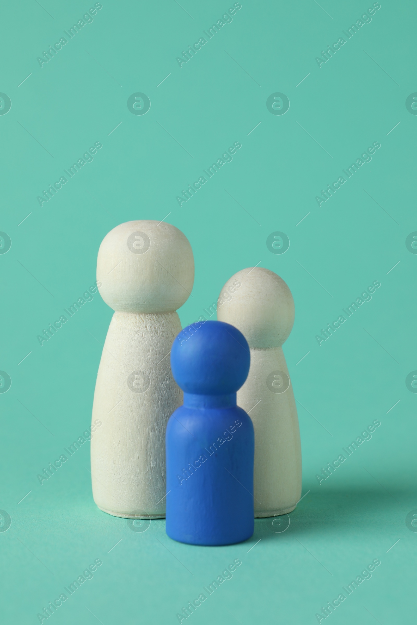 Photo of Group of wooden human figures on turquoise background