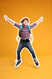 Happy school child with backpack jumping on orange background