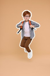 Cute school child with backpack jumping on dark beige background